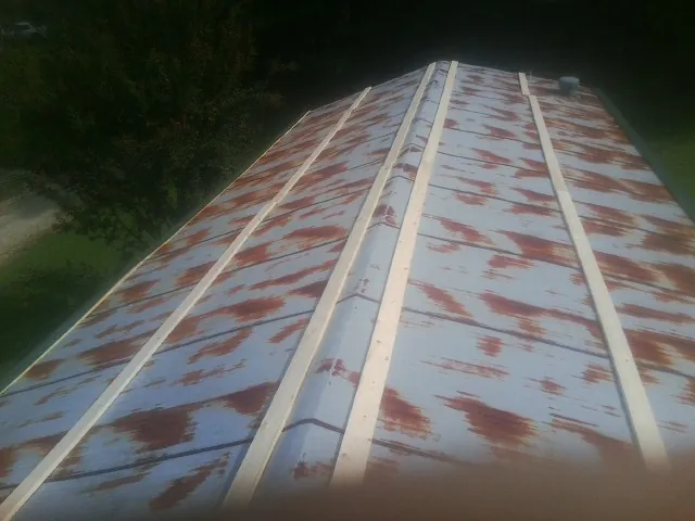 Rusted metal roof panels with new wood purlins before replacement — Storm Damage Roof Repair in Chocowinity by Roofing Brothers