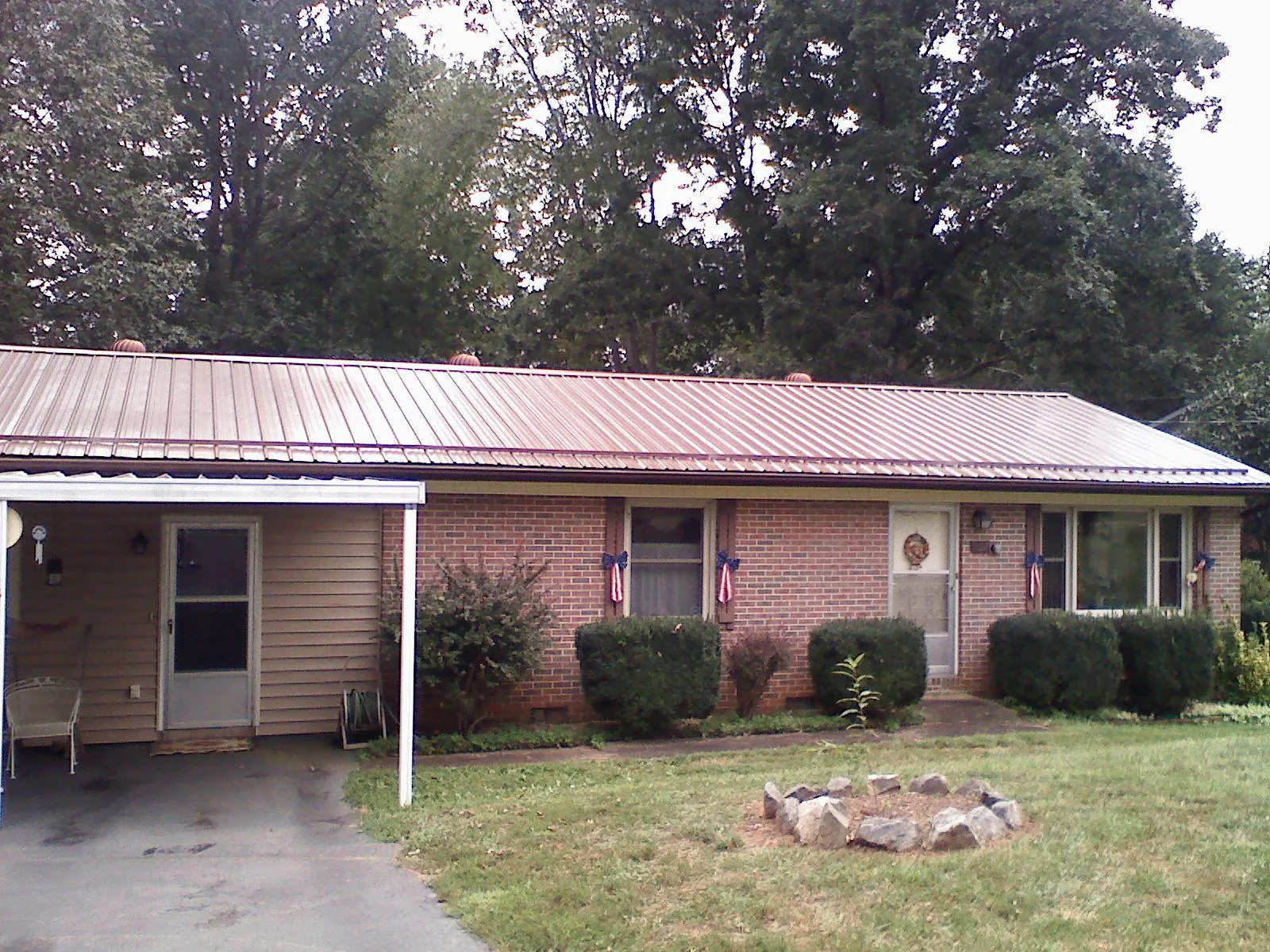 Bronze metal roof and carport on a brick ranch home — Roof Repair work by our crew in Chocowinity